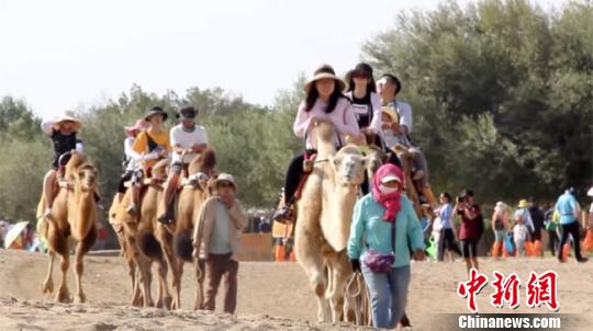The picture shows that at the end of August, Dunhuang Mingsha Mountain "camel man" walked in the desert. Gao Ying photo